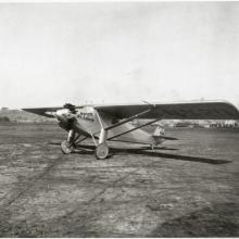 The Spirit of St. Louis, a monoplane with one engine, on flat land.