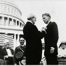 Charles Lindbergh receives a medal at a ceremony following his feat as the first to pilot alone during a nonstop transatlantic flight.