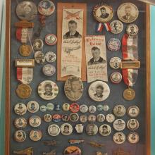 A collection of pins and ribbons celebrating Charles Lindbergh's flights.