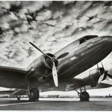 Front view of a commercial aircraft with twin, three-blade propellor engines.