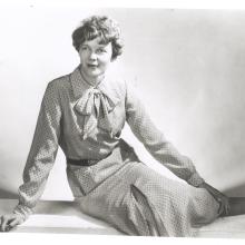 Amelia Earhart sits as she models clothing that she designed and made herself.