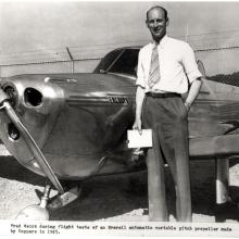 Fred Weick, a white man, stands next to his metal aircraft.