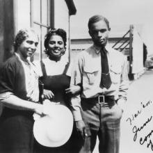 Three African-American people, including Willa Brown and Perry Young, stand together at an airport. 