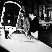 Isaac Gilliam IV, an African-American male, stands next to another man near a white aircraft.