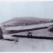 Single-person glider with steel tube frame on ground.