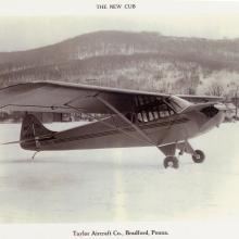 Side view of light-colored monoplane with one engine on ground.