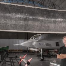 Jacques Garnier, white male co-photographer artist of "The Great Picture", stands in front of the large photo.