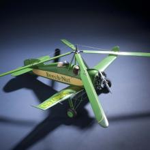 Top view of green and yellow monoplane model with one engine and rotating four-blade propellor above the cockpit. Registration number "NC10780" is painted on the right wing and the name "Beech-Nut" is painted in green.