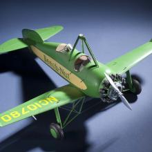 Top view of green and yellow monoplane model with one engine. Registration number "NC10780" is painted on the right wing and the name "Beech-Nut" is painted in green.