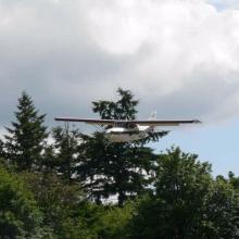 Back view of a white and red monoplane in flight.