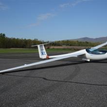 Side view of white glider monoplane with abnormally long wings.