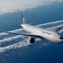 A Boeing 777 commercial jet with white, blue, and yellow United Airlines livery.