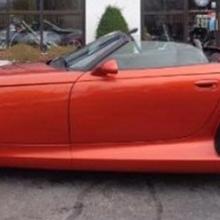 Side view of red, two-seat convertible automobile.