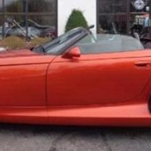 Side view of red, two-seat convertible automobile.