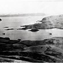 Two aircraft fly directly over a large body of water.