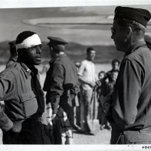 Lt. Andrew D. Mitchell, an African-American male pilot on the left, speaks to another officer following an escape attempt from German territory.