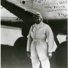 John C. Robinson, an African-American male pilot, poses informally in front of an aircraft.