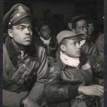 African-American male pilots listen to a mission briefing together.