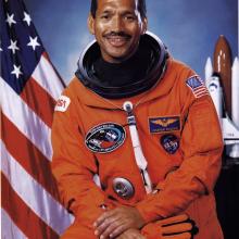 Charles F. Bolden Jr., an African-American male astronaut, poses formally in his astronaut suit.