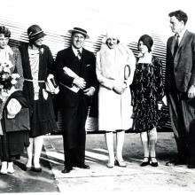 Amelia Earhart, a white woman, stands with other white people including Charles and Anne Lindbergh, featured on the right.