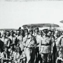 A large group of Marine Corps pilots in the early 1930s stand together outdoors for a portrait.