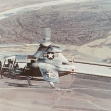 Side view of a gray, experimental aircraft designed like a helicopter but intended to have speeds similar to an airplane. A one-blade propellor is visible.