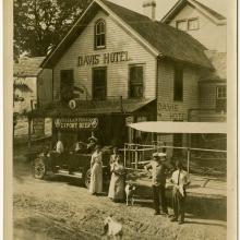 Harry Bingham Brown, a white male pilot, stands outside of a hotel named "Davis' Hotel" with other people.