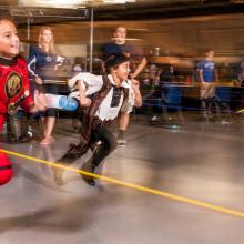 Two kids wearing Halloween costumes participate in a rocket activity during a Halloween event at the Museum.