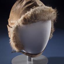 Brown aviation helmet with leather outer lining and fur-lined interior. Styled on mannequin.