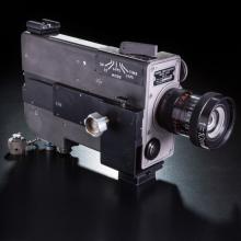 Film camera with rectangular prism base and single lens.