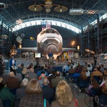 Museum visitors listen to a presentation in the Space Hangar of the Steven F. Udvar-Hazy Center during an open house event.