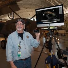 A Museum staff member uses a display monitor to provide photography advice at an open house event for the Museum.