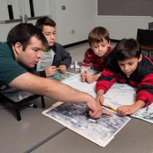 A family of four people look at maps as part of a game at the Udvar-Hazy Center.