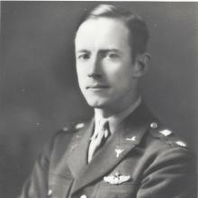 A white man in a military uniform looks at the camera.