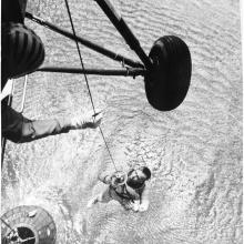 A Navy helicopter hoists Alan Shepard from the ocean after his flight.