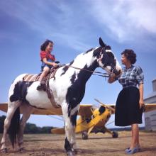 A girl, her pony, and a Piper J-3C Cub