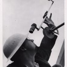 Gawain Edward “Ed” Pendray, a man, uses a tracking device to view rocket flight tests.