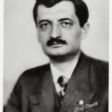 A portrait of a man with a black mustache wearing a suit.