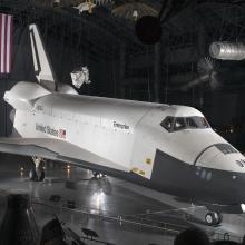 Side view of white and black space shuttle on display at the museum.