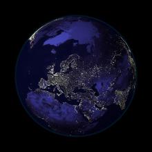 A satellite view of Earth during nighttime hours, with a focus on Europe and Northern Africa which has many lights visible from space.