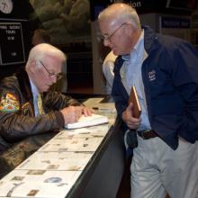 Astronaut Gene Cernan Signs an Autograph