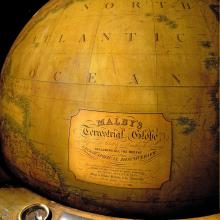 View of nineteenth-century wooden globe focusing on branding below markings indicating North Atlantic Ocean