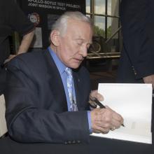 Buzz Aldrin signs book for a fan