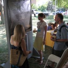 A woman stands at the Folklife Festival among festival patrons.