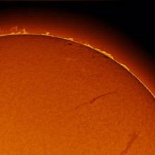 A part of the sun with prominences of plasma floating above the sphere