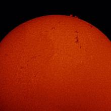 A view of part of the Sun featuring filaments of steam and prominences of plasma rising from the sun.