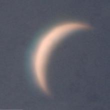 View of Venus as a thin waning crescent during daytime.