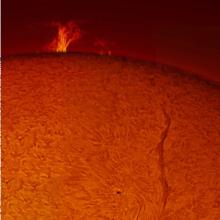 View of the Sun focused on a large prominence of plasma floating away from the Sun and a snake-shaped filament on the disc.