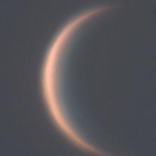 View of Venus as a thin waxing crescent during daytime hours.