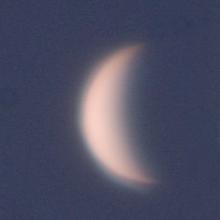 View of Venus as a waxing crescent in the daytime sky.